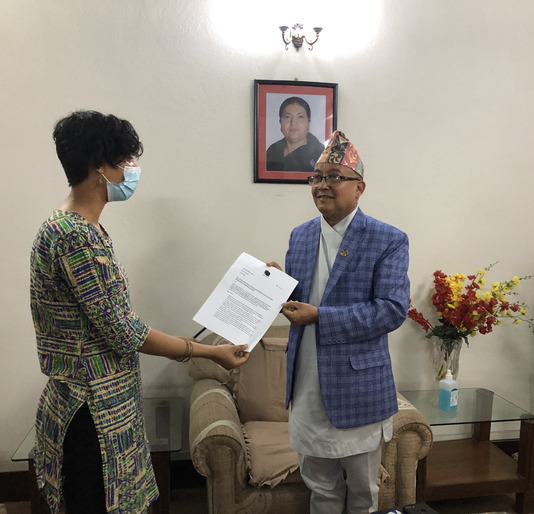 A photo where Shubha is handing the signature petition with our organisational demands to Chief Election Commissioner of Nepal